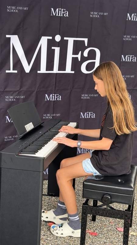 Blonde student playing piano outdoors